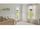 Bright Bedroom featuring a wooden crib, striped wallpaper, and access to an outdoor balcony with neighborhood views at 133 Threaded Fern St, Summerville, SC 29485