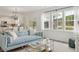 Bright living room with a view of the lake, featuring a blue sofa and modern decor at 133 Threaded Fern St, Summerville, SC 29485