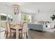 Open-concept living and dining area featuring modern furniture, a stylish chandelier, and lots of natural light at 133 Threaded Fern St, Summerville, SC 29485