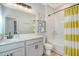 Bright bathroom featuring a double vanity, subway tiled shower and yellow striped shower curtain at 142 Midtown Ave, Summerville, SC 29486
