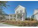 Charming two-story home featuring a inviting front porch with traditional design elements and a well-manicured lawn at 142 Midtown Ave, Summerville, SC 29486