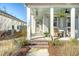 Inviting front porch with rocking chairs, hanging plants, and brick steps showcasing the entrance to the charming home at 142 Midtown Ave, Summerville, SC 29486