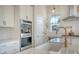 Bright kitchen with stainless steel appliances, white cabinets, herringbone backsplash, and a farmhouse style sink at 142 Midtown Ave, Summerville, SC 29486