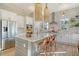 Modern kitchen featuring white cabinets, stainless steel appliances, large island with pendant lighting, and herringbone backsplash at 142 Midtown Ave, Summerville, SC 29486