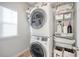Modern laundry room featuring a stacked washer and dryer with wire basket shelving and a window for natural light at 142 Midtown Ave, Summerville, SC 29486