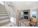 Bright living room with a modern fireplace, hardwood floors, and staircase to the second floor at 142 Midtown Ave, Summerville, SC 29486