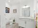 Bright bathroom featuring white cabinets, marble countertop, toilet, and decorative art at 155 Wingo Way # 421, Mount Pleasant, SC 29464