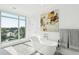 A modern bathroom with a standalone tub positioned in front of a large window with palm tree views at 155 Wingo Way # 421, Mount Pleasant, SC 29464