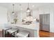 An island provides seating in this kitchen featuring stainless steel appliances and marble countertops at 155 Wingo Way # 421, Mount Pleasant, SC 29464