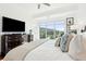 Bright primary bedroom featuring large windows and wooden dresser with large screen tv at 155 Wingo Way # 421, Mount Pleasant, SC 29464