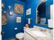 Cozy powder room featuring blue walls, granite countertop, decorative mirror and woven wall art at 1662 Hunters Run Dr, Mount Pleasant, SC 29464