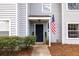 Welcoming townhouse entrance featuring a dark door, green shrubs, and an American flag at 1662 Hunters Run Dr, Mount Pleasant, SC 29464