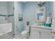 Bright bathroom with a glass-enclosed shower, white vanity, modern lighting, and stylish blue accents at 18 Logan St, Charleston, SC 29401