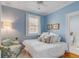 Inviting bedroom with blue walls, hardwood floors, a comfortable bed with plush pillows, and a sunlit window at 18 Logan St, Charleston, SC 29401