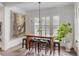 Dining area with wooden table, stools, pendant lighting, shuttered windows, and decorative wall art at 18 Logan St, Charleston, SC 29401