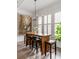 Dining table with six stools, pendant lighting, and bright windows with white shutters in an airy dining space at 18 Logan St, Charleston, SC 29401
