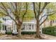 Elegant two-story home with a grand porch, lush landscaping, and mature trees at 18 Logan St, Charleston, SC 29401