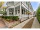 Elegant two-story home featuring a wrap-around porch, lush landscaping, and a private driveway at 18 Logan St, Charleston, SC 29401