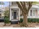 Stately home entrance with a grand tree, brick steps, classic columns, and a black front door at 18 Logan St, Charleston, SC 29401