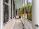 Inviting front porch with hanging plants, classic columns, detailed railings, and black shutters at 18 Logan St, Charleston, SC 29401