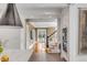 View from the kitchen through a hallway, featuring hardwood floors, and a staircase with white railings at 18 Logan St, Charleston, SC 29401
