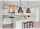 Bright kitchen boasts white cabinets, an island with seating, quartz countertops, and stainless steel appliances at 18 Logan St, Charleston, SC 29401