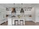 Bright kitchen showcasing a large island with bar stools, stainless steel appliances, and white cabinets at 18 Logan St, Charleston, SC 29401