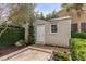 Charming outbuilding with beige siding, white door, and brick-lined patio, surrounded by lush greenery at 18 Logan St, Charleston, SC 29401