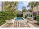 Backyard oasis with a refreshing pool, comfortable lounge chairs, lush greenery, and a charming dining area at 18 Logan St, Charleston, SC 29401