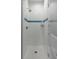 Modern shower with white subway tile, blue accent stripes, and mosaic tile flooring at 18 Logan St, Charleston, SC 29401