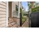 Side entrance featuring brick stairs, white railing, and a charming black gate leading to the backyard at 18 Logan St, Charleston, SC 29401