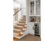 Staircase near a custom bar area with glass-front cabinets, counter, and wine fridge at 18 Logan St, Charleston, SC 29401