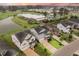 Aerial view of several homes near a pond, showing the community layout and proximity to a local school at 213 Palmetto Walk Dr, Summerville, SC 29486