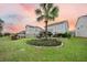 Beautiful backyard with a lush lawn, patio seating, and a central palm tree feature, perfect for outdoor relaxation at 213 Palmetto Walk Dr, Summerville, SC 29486