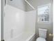 Clean white bathtub with tile surround, shower head, and a window with blinds and gray walls at 2176 Andover Way, Mount Pleasant, SC 29466