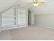 Spacious bonus room features built-in shelving, neutral carpet, and ceiling fan with light at 2176 Andover Way, Mount Pleasant, SC 29466