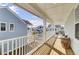 Long covered balcony with wood floors and white railings offering neighborhood views and outdoor seating at 225 Bird Song Path, Summerville, SC 29485