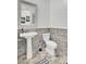 Stylish half-bathroom with a pedestal sink, toilet, and decorative shiplap and stone accent wall at 225 Bird Song Path, Summerville, SC 29485