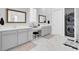 A modern primary bath with dual sinks, vanity, and a stacked washer and dryer at 225 Bird Song Path, Summerville, SC 29485