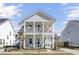 Charming two-story home with a welcoming double front porch and manicured landscaping at 225 Bird Song Path, Summerville, SC 29485