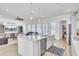 Bright open-concept living area with kitchen island, ceiling fan, and view of the living room and rear windows at 225 Bird Song Path, Summerville, SC 29485