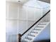 Elegant staircase with contrasting dark wood rail and white spindles and paneled walls at 225 Bird Song Path, Summerville, SC 29485