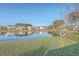 Backyard view of pond reflecting nearby homes, lawn, and trees on a sunny day at 232 Decatur Dr, Summerville, SC 29486