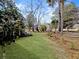Lush green lawn and mature trees create a tranquil backyard oasis with landscaped borders at 2419 Tuscany Dr, North Charleston, SC 29406