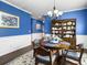 Dining room with blue walls, built-in hutch, crown molding, and elegant decor at 2419 Tuscany Dr, North Charleston, SC 29406