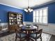 Formal dining room with blue walls, white crown molding, and shuttered windows at 2419 Tuscany Dr, North Charleston, SC 29406