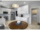 Bright kitchen featuring white cabinetry, stainless steel appliances, and a wood breakfast table at 2419 Tuscany Dr, North Charleston, SC 29406