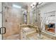 Well-lit bathroom with granite counters, glass shower doors, and tiled shower at 25 Logan St, Charleston, SC 29401