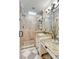 Bathroom with granite counters, glass shower doors, decorative mirrors and checkered floors at 25 Logan St, Charleston, SC 29401