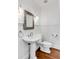 Elegant powder room with pedestal sink, framed mirror, and wainscoting at 25 Logan St, Charleston, SC 29401